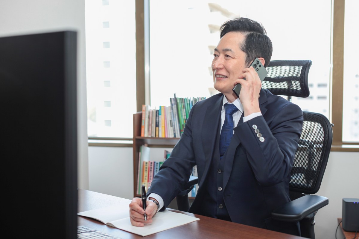 執務室で電話を受ける佐藤英之弁護士（仙台弁護士会所属）