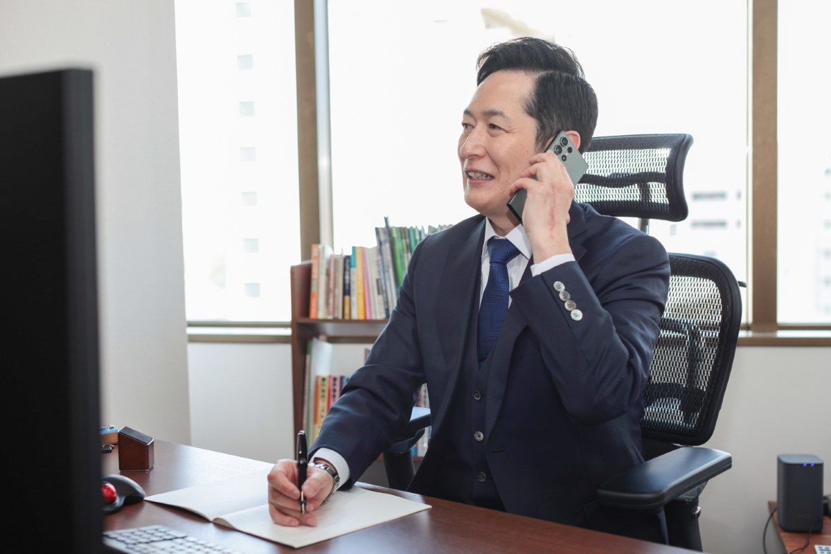 執務室で電話を受ける佐藤英之弁護士（仙台弁護士会所属）
