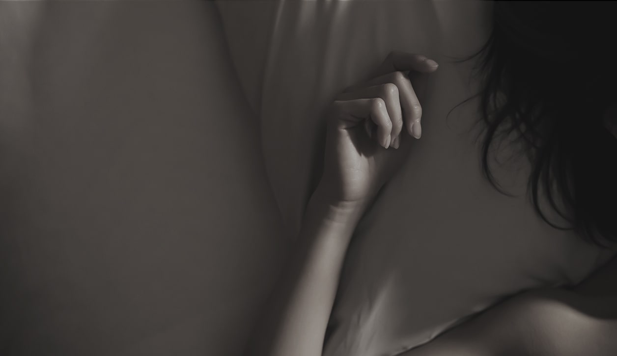 ベッドに仰向けで横たわる女性